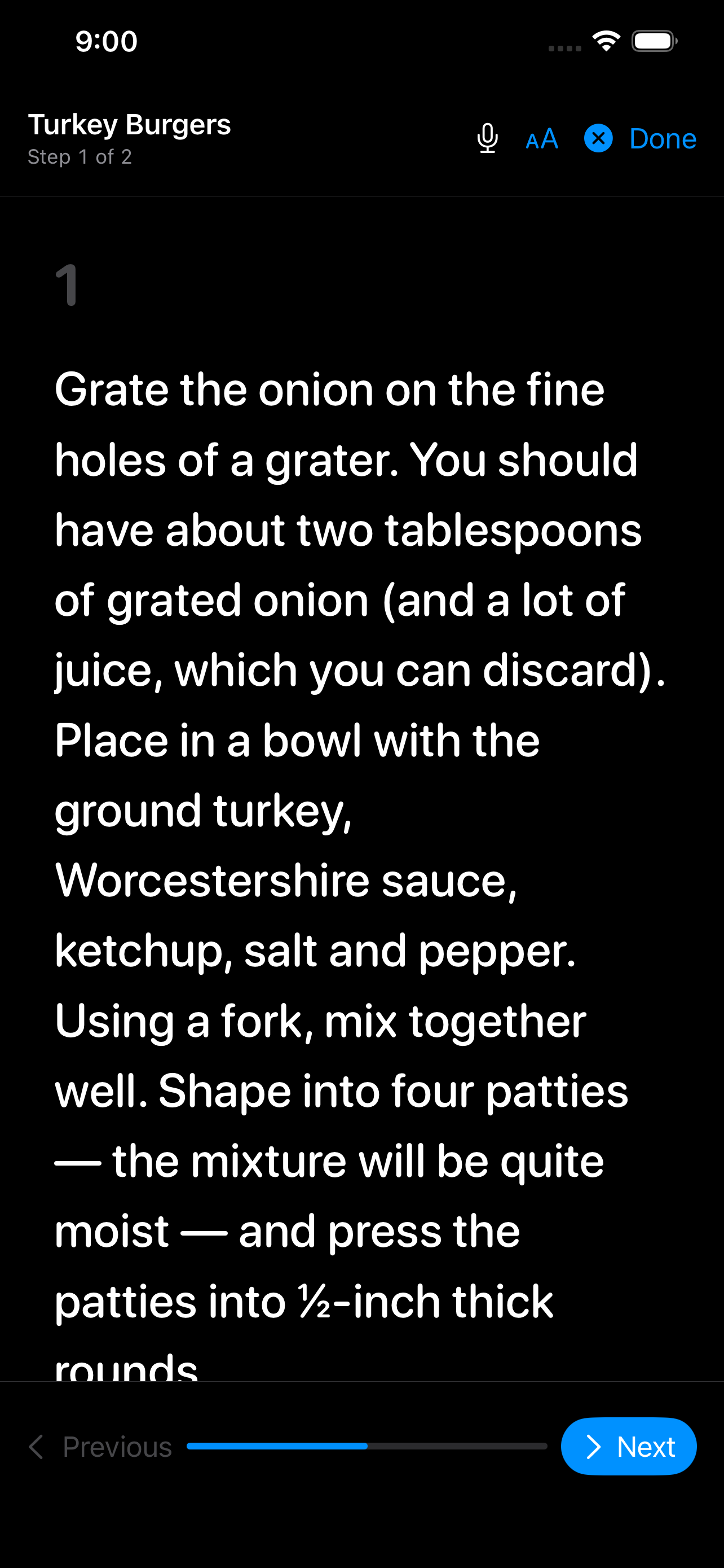 Cook mode on iPhone &mdash; step 1 of 2 set large enough to read from across the kitchen, with a microphone button for hands-free control, a text-size control, and Previous and Next along a progress bar