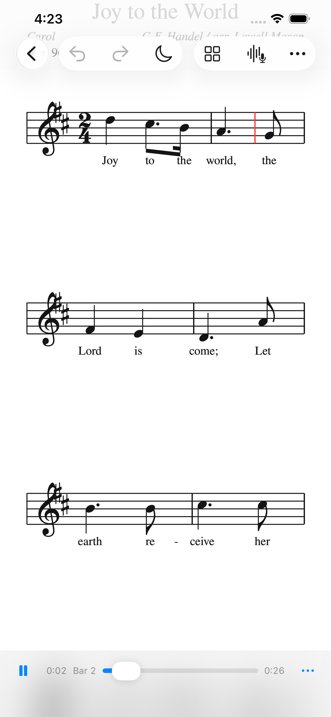 Playback on iPhone &mdash; Joy to the World engraved with its lyrics under the notes, the playhead marked in red partway through the first system, and a transport reading 0:02, bar 2 of 0:26, with undo, redo, a night-mode moon and a microphone button in the toolbar